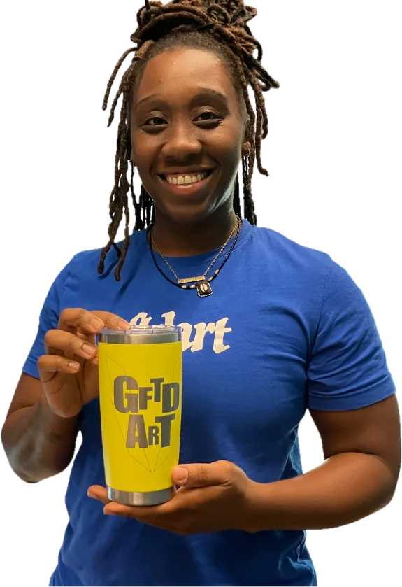 A smiling educator holding a yellow travel mug she laser-engraved with a GFTD ART design
